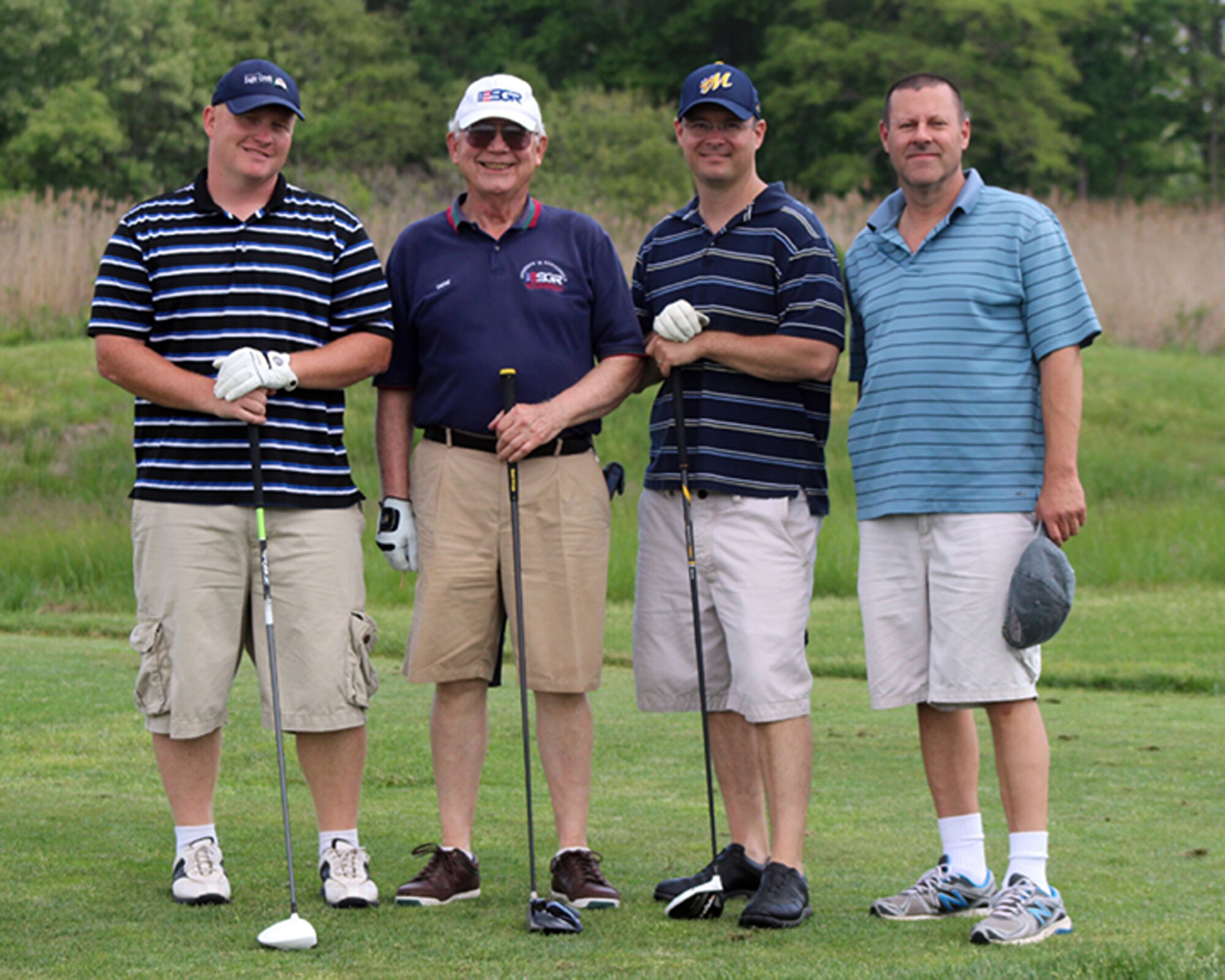 From left to right, Tech. Sgt. Chance Wisdom, 736th Aircraft Maintenance Squadron, Gene Herbert, Employer Support of the Guard and Reserve, Maj. Jason Pennypacker, 326th Airlift Squadron, and Edward Lau, Defense Contracting Management Agency, pose for a team photo at the Jonathan's Landing Golf Course in Magnolia, Del., May 15, 2014. The team shot a score of 1 under 70 during the annual Central Delaware Chamber of Commerce Bluesuiters Golf Tournament, held annually to promote the relationship between the Dover civilian community and the Dover Air Force Base community. (U.S. Air Force photo/Herbert E. Welday III)