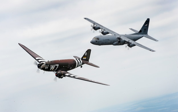 A Douglas C-47 Skytrain, known as Whiskey 7, flies alongside a C-130J Super Hercules from the 37th Airlift Squadron over Germany, May 30, 2014. The C-47 came to Ramstein for a week to participate in base activities with its legacy unit, the 37th Airlift Squadron, before returning to Normandy to recreate its role and drop paratroopers over the original drop zone in Sainte-Mere Eglise, France. (U.S. Air Force photo/Staff Sgt. Sara Keller)