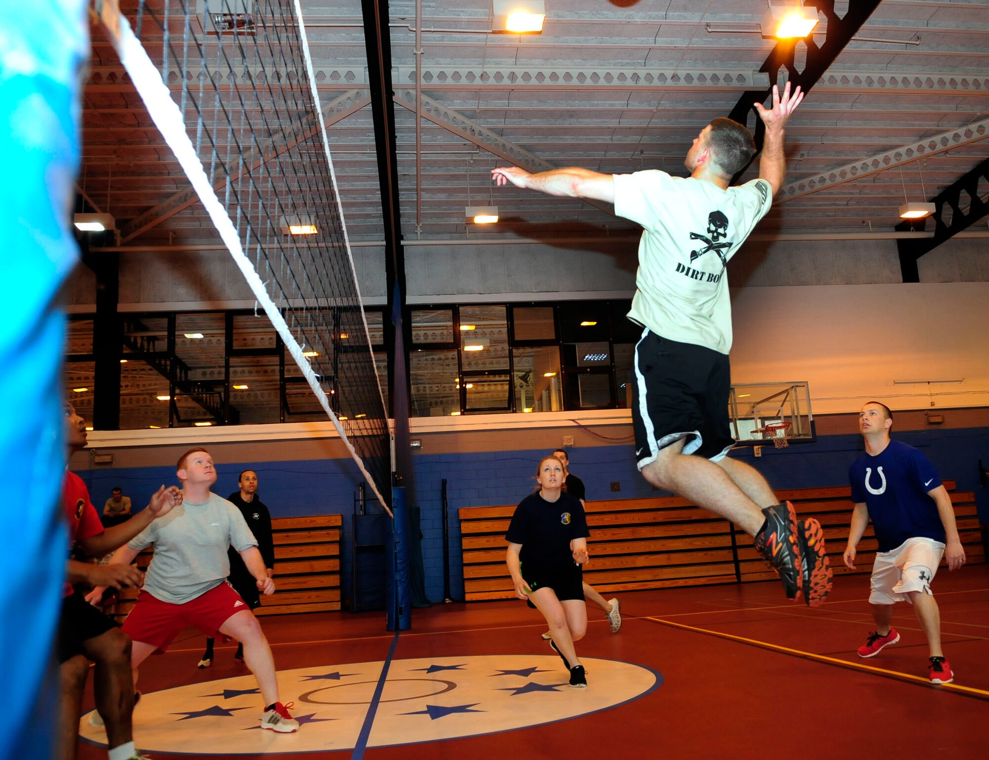 U.S. Air Force Senior Airman Michael Sternberg, second from right, 100th Civil Engineer Squadron heavy equipment  from Panhandle, Texas, leaps to return the ball during a volleyball match between the 100th CES and the 100th Communications Squadron May 30, 2014, during the 100th Mission Support Group sports day on RAF Mildenhall, England. The 100th CES team won the match 21-6. (U.S. Air Force photo/Karen Abeyasekere/Released)