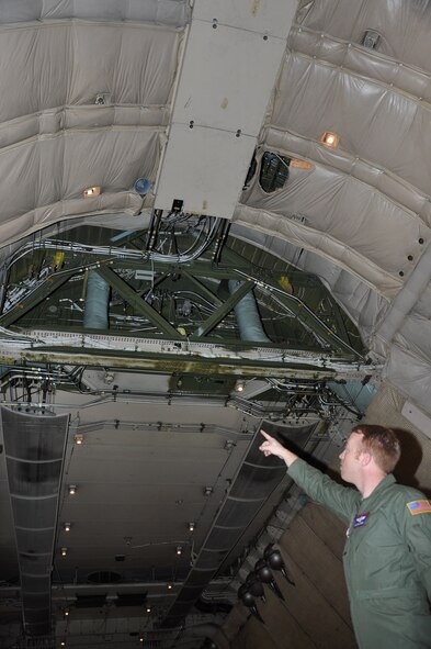 Staff Sgt. Will Harden, 22nd Airlift Squadron evaluator loadmaster, points at the section of the cargo hold where the troop compartment has been removed in the C-5C Space Cargo Modified Galaxy May 28 at Travis. The 22nd AS routinely supports National Aeronautics and Space Administration and other agencies by delivering assets throughout the nation as well as local missions. (U.S. Air Force photo/ Staff Sgt. Christopher Carranza)