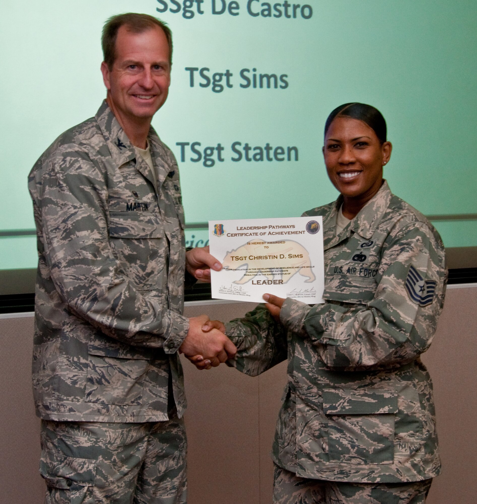 Tech. Sgt. Christin Sims, 570th Global Mobility Squadron, receives recognition by Col. Corey Martin May 21 for achieving the "Warrior" level in Leadership Pathways. (U.S. Air Force photo/Senior Airman Charles V. Rivezzo)
