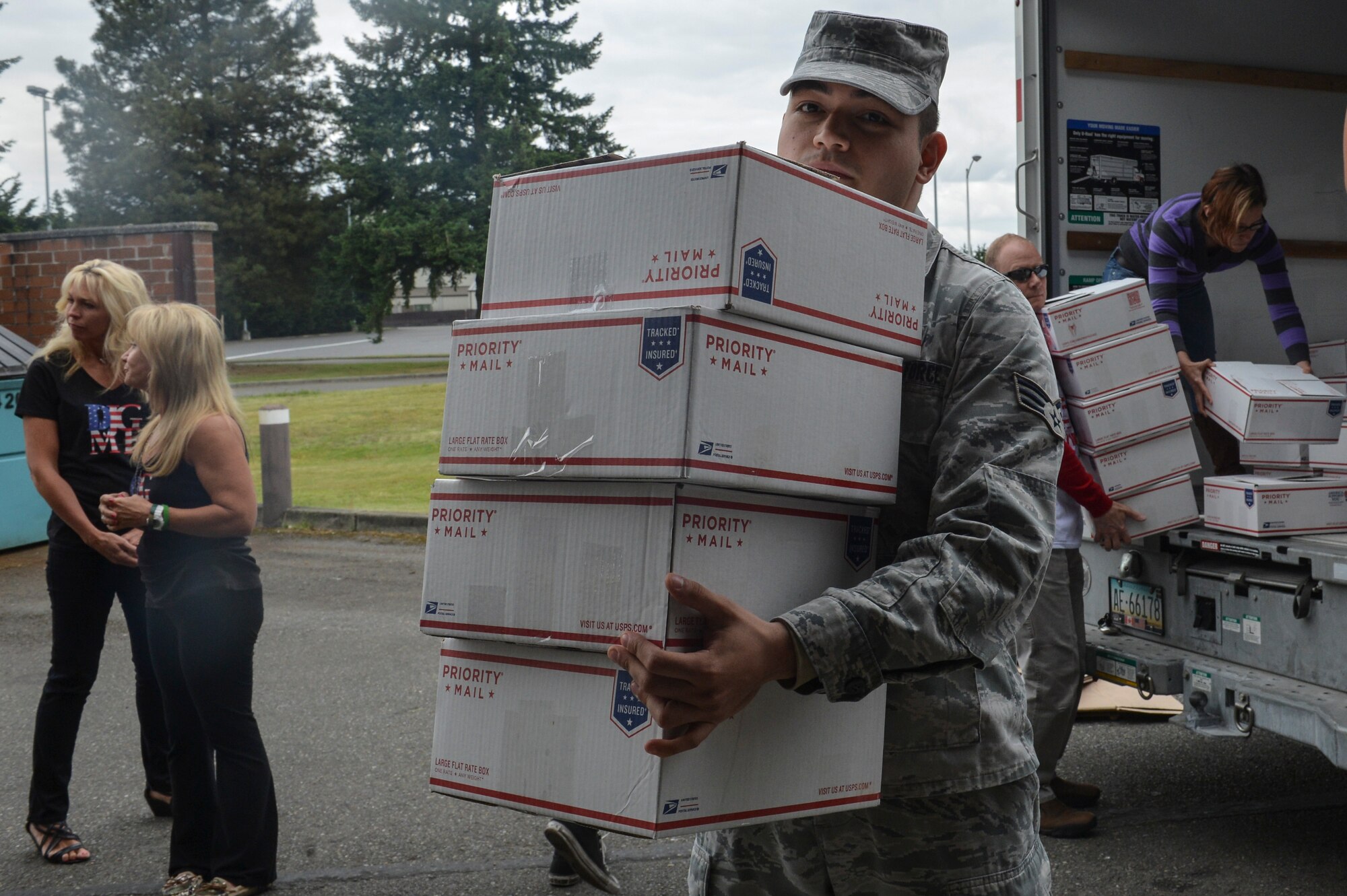Senior Airman Jose Frias, 62nd Aerial Port Squadron passenger terminal representative, volunteers to help offload 1,000 care packages for service members deployed overseas, May 29, 2014, at Joint Base Lewis-McChord. Each box contains comfort foods and toiletries in hopes of boosting moral and providing a sense of home for those serving in war zones. (U.S. Air Force photo/Staff Sgt. Russ Jackson) 