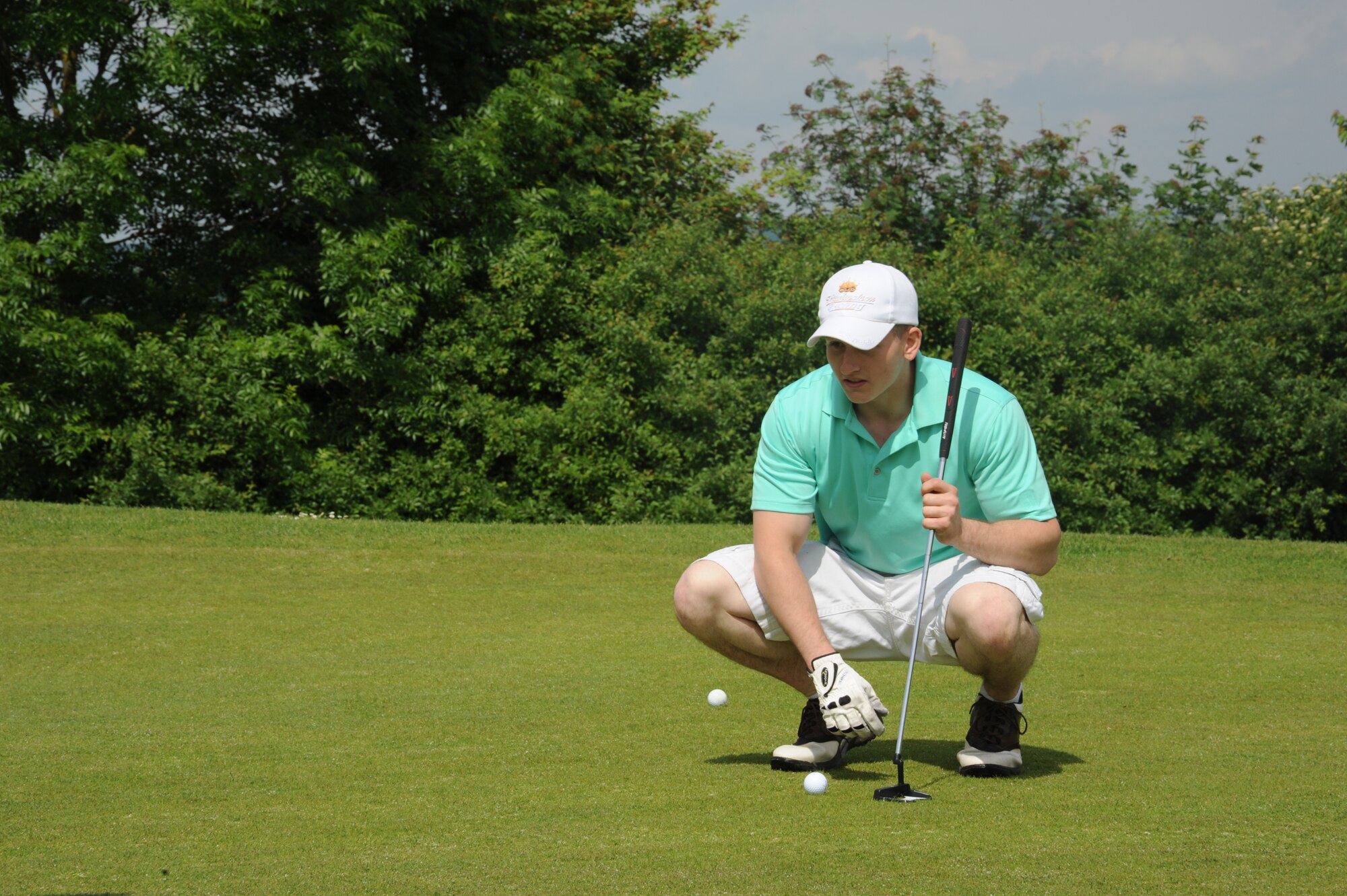 U.S. Air Force Senior Airman Michael Edwards, 606th Air Control Squadron radio frequency transmissions journeyman, aligns his putt during the wing sports day golf tournament May 29, 2014, at Spangdahlem Air Base, Germany. The 52nd Civil Engineer Squadron took home the overall title for wing sports day. (U.S. Air Force photo by Airman 1st Class Dylan Nuckolls/Released)