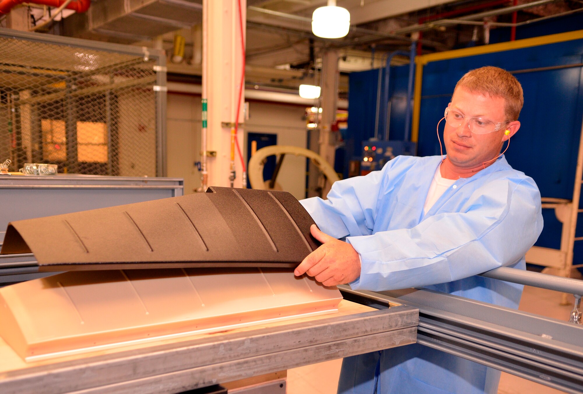 Chad Lemoine, 573rd Composites Shop plastic worker, operates the base’s new plastic thermo forming machine in Bldg. 670.(U.S. Air Force photo by Ed Aspera)