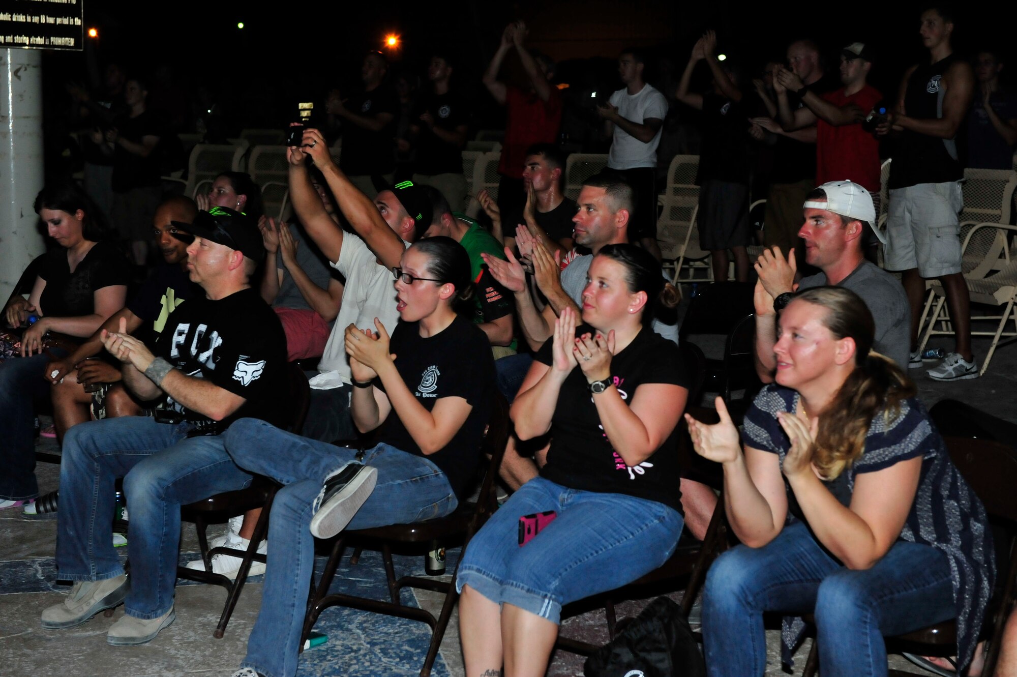 Service members applaud during a Darryl Worley performance at Al Udeid Air Base, Qatar, May 25, 2014. Worley sang many of his top hits, and played a few fan requests for the audience. (U.S. Air Force photo by Senior Airman Colin Cates)