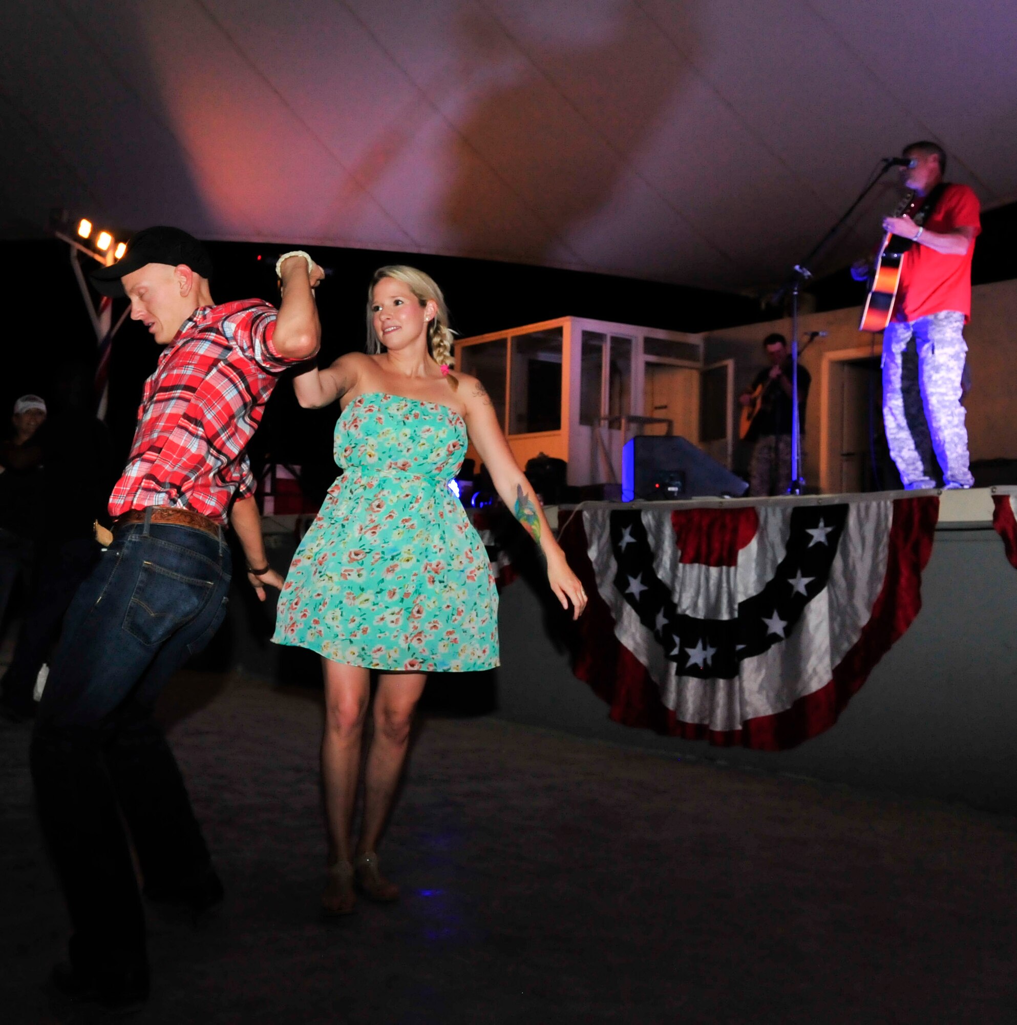 Service members dance during a Darryl Worley a performance at Al Udeid Air Base, Qatar, May 25, 2014. This was Worley’s first time at AUAB. (U.S. Air Force photo by Senior Airman Colin Cates)