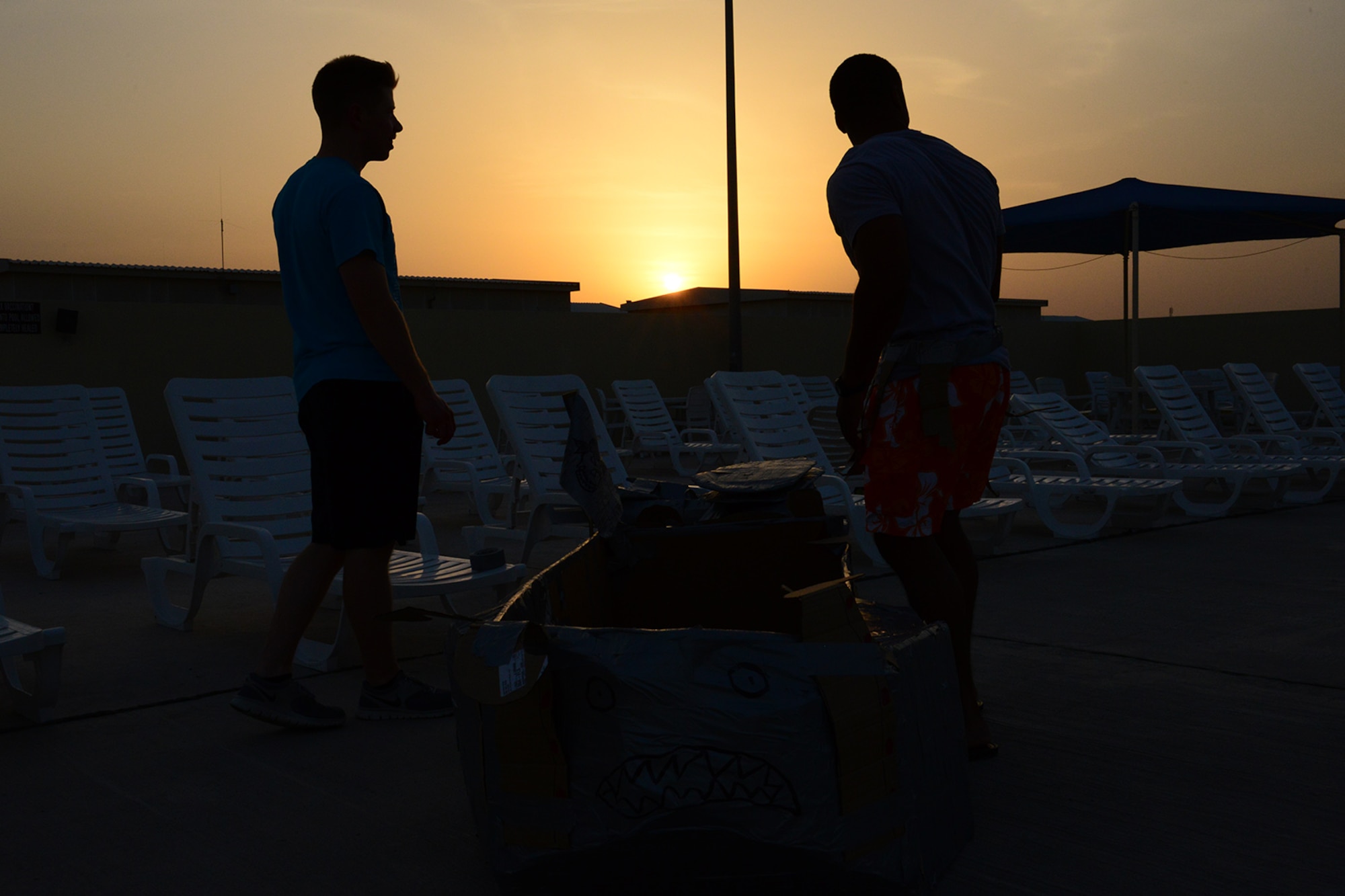 U.S. Air Force Airmen prepare for a cardboard boat regatta at Al Udeid Air Base, Qatar, May 23, 2014. The regatta is a boat race, where teams compete using a boat made of mainly cardboard and tape, to stay afloat. (U.S. Air Force photo by Staff Sgt. Ciara Wymbs)  