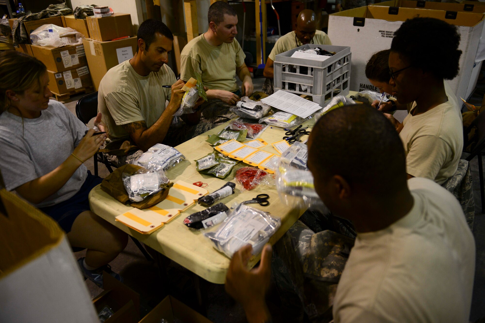U.S. Air Force Airmen assigned to the 379th Air Expeditionary Wing pack, sort and label individual first aid kits at Al Udeid Air Base, Qatar, May 23, 2014. The IFAKs at AUAB are recertified and distributed throughout the U.S. Central Command area of responsibility. (U.S. Air Force photo by Staff Sgt. Ciara Wymbs)