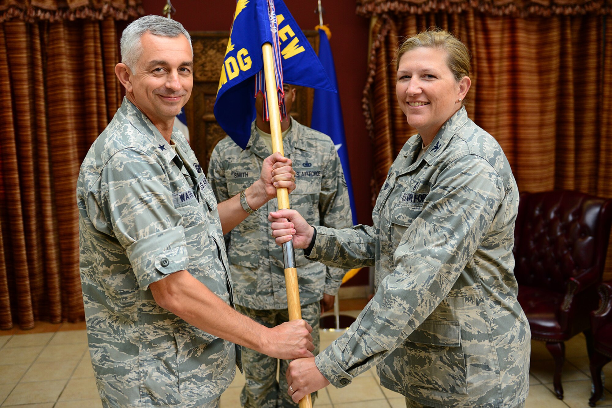 U.S. Air Force Brig. Gen. Roger H. Watkins, 379th Air Expeditionary Wing commander, passes the guidon to Col. Andrea Vinyard, incoming 379th Expeditionary Medical Group commander, at Al Udeid Air Base, Qatar, May 25, 2014. Prior to taking command, Vinyard was assigned to the U.S. Air Force Surgeon General’s office as the expeditionary policy, programs and operations division chief. (U.S. Air Force photo by Staff Sgt. Ciara Wymbs) 