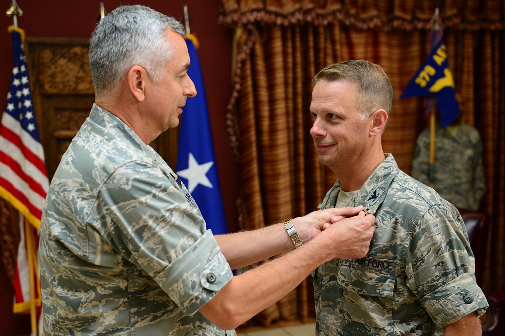 U.S. Air Force Brig. Gen. Roger H. Watkins, 379th Air Expeditionary Wing commander, pins the Bronze Star medal on Col. Gregory DeWolf, outgoing 379th Expeditionary Medical Group commander, at Al Udeid Air Base, Qatar, May 25, 2014. DeWolf is leaving AUAB to command the 82nd Medical Group at Sheppard Air Force Base, Texas. (U.S. Air Force photo by Staff Sgt. Ciara Wymbs)