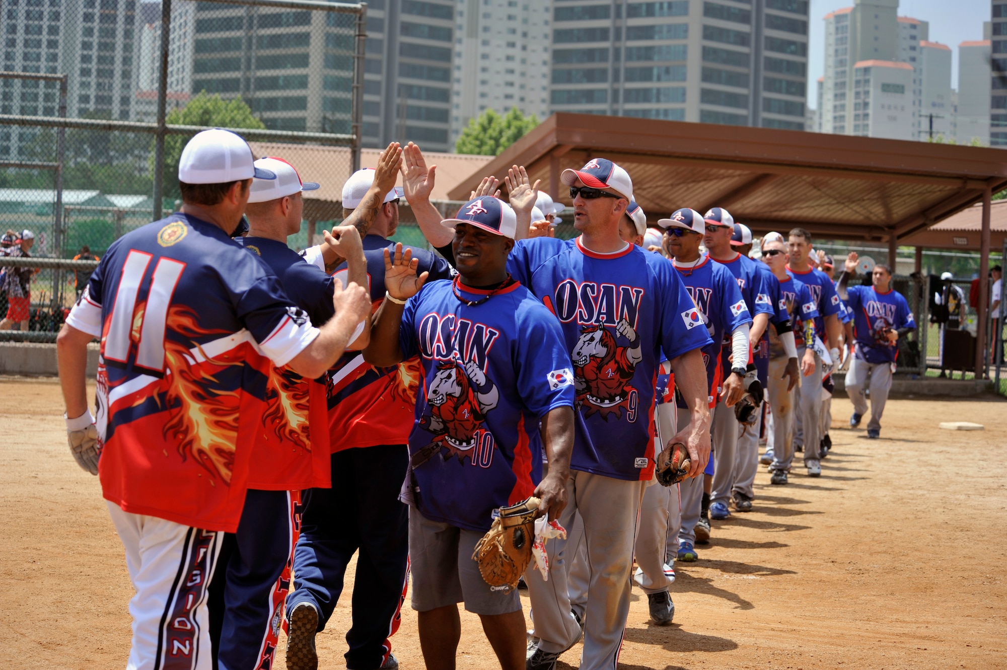 Members of the Osan men’s softball team congratulate the Legion team after the tournament semifinals game on U.S. Army Garrison Yongsan, Republic of Korea, May 26, 2014. Legion defeated Osan 19-8 and the Mustangs finished the tournament in third place. (U.S. Air Force photo/Senior Airman David Owsianka)