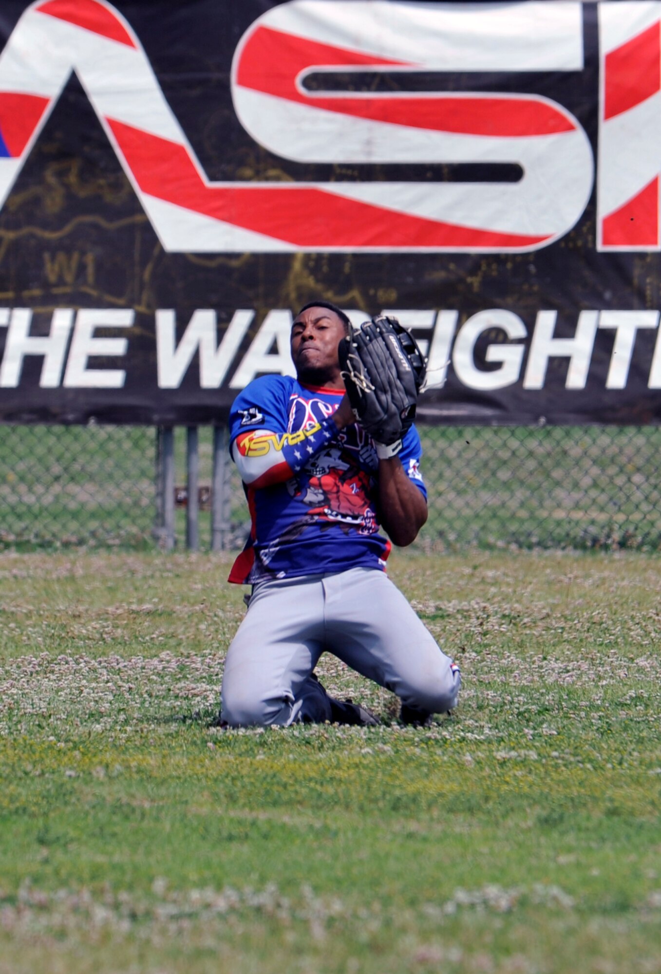 Staff Sgt. Mikkel McKoy, 7th Air Force, slides on his knees to make a catch during the fourth inning of the quarterfinals game against the Legion team during a tournament on U.S. Army Garrison Yongsan, Republic of Korea, May 26, 2014. Osan lost the game 29-19 and moved to the loser’s bracket. (U.S. Air Force photo/Senior Airman David Owsianka)