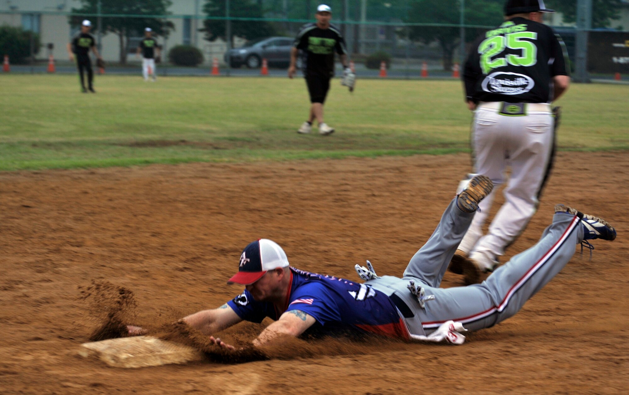 Senior Master Sgt. Jamie Cummins, 51st Maintenance Squadron, slides safely into third base during the fifth inning of a game against the Joint Task Force team on U.S. Army Garrison Yongsan, Republic of Korea, May 25, 2014. Osan won the game 33-22 and moved on to the quarterfinals. (U.S. Air Force photo/Senior Airman David Owsianka)
