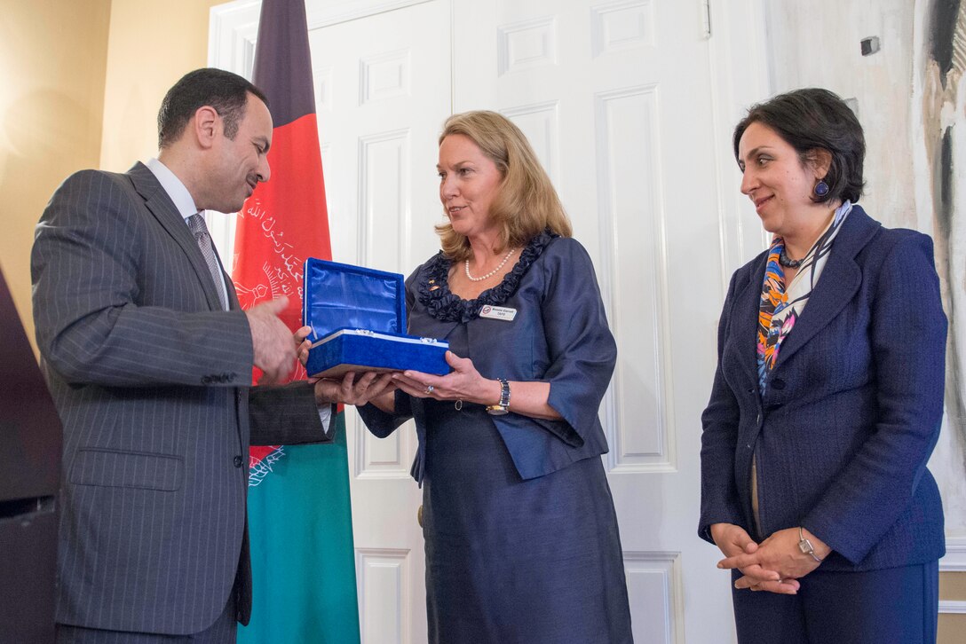 Eklil Hakimi, Afghan ambassador to the United States, presents Bonnie Carroll with a gift for her work as the president and founder of Tragedy Assistance Program for Survivors, or T.A.P.S., during a dinner in honor of U.S. military service members killed in Afghanistan. The dinner was hosted by Hakimi at his residence in Washington D.C., May 29, 2014. T.A.P.S. is a tragedy assistance resource for anyone who has suffered the loss of a military loved one. 