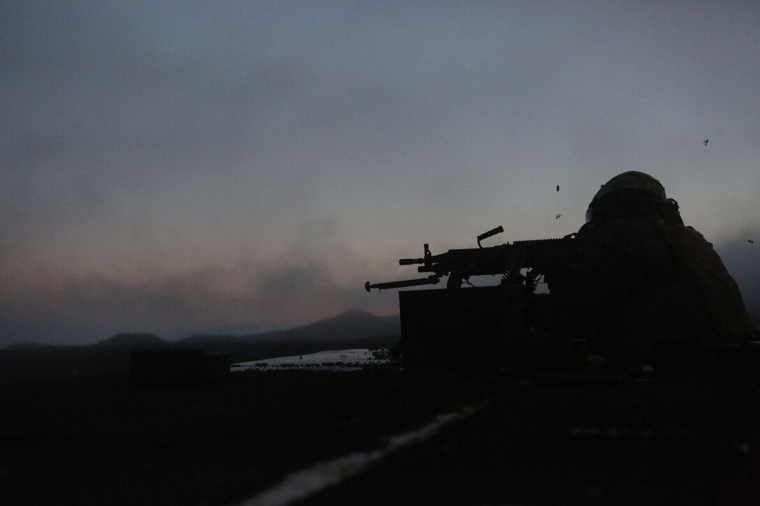 A machine gunner with Weapons Company, 3rd Battalion, 3rd Marine Regiment fires a M249 light machine gun during a live fire night shoot here, May 28. The Marines were being tested on whether they could keep security throughout the night and effectively fire upon targets.