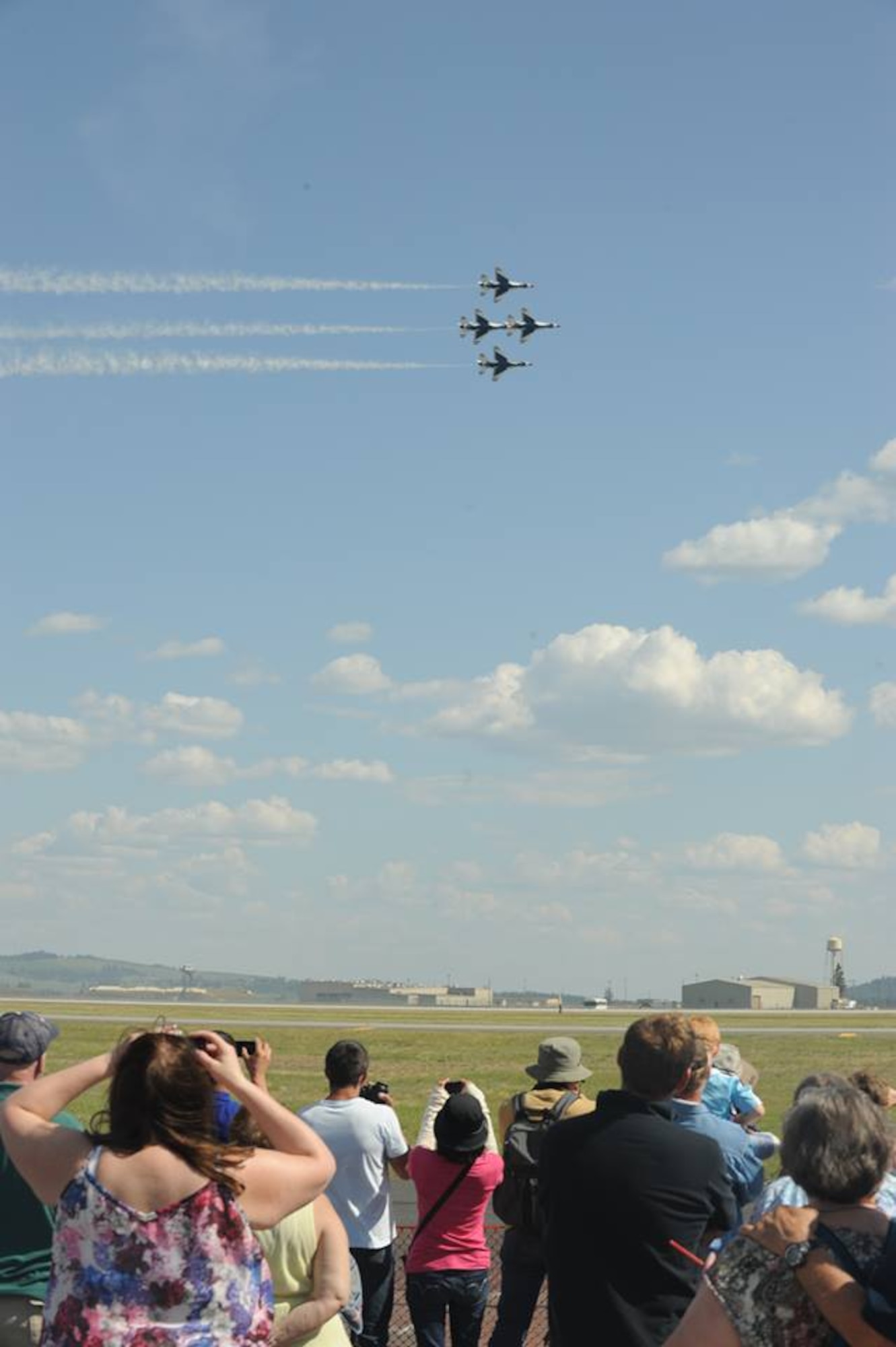 Spectators watch the Thunderbirds segment of SkyFest 2014 at Fairchild Air Force Base, Wash., May 31, 2014. The performance was the final flying sequence of the day. The Thunderbirds have flown the F-16 Fighting Falcon since August 1982, more than half of the team's history. SkyFest is Fairchild’s air show and open house, giving the local and regional community the opportunity to view Airmen and our resources. (U.S. Air Force photo by Airman 1st Class Sam Fogleman/Released)