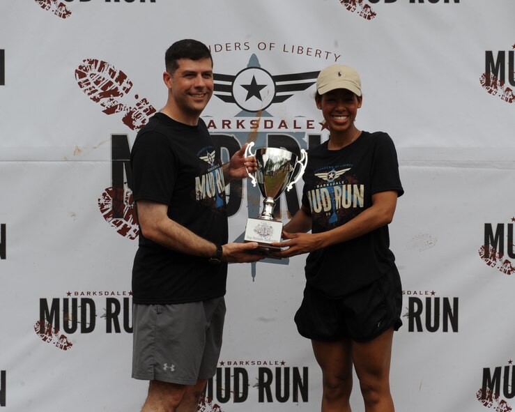 Capt. Cherelle Small, 2nd Logistics Readiness Squadron, receives the first place female trophy from Col. Andrew Gebara, 2nd Bomb Wing commander, during the 2014 Defenders of Liberty Mud Run on Barksdale Air Force Base, La., May 31. Small completed the Mud Run in 49:49. (U.S. Air Force photo/Senior Airman Benjamin Gonsier)