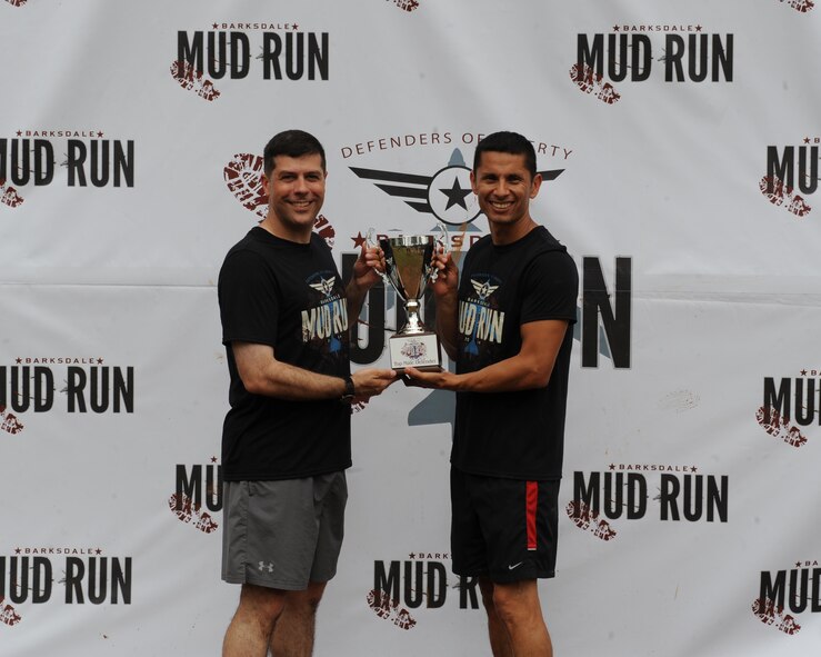 Senior Master Sgt. Randall Kingfisher, Air Force Global Strike Command, receives the first place male trophy from Col. Andrew Gebara, 2nd Bomb Wing commander, during the 2014 Defenders of Liberty Mud Run on Barksdale Air Force Base, La., May 31. Kingfisher completed the Mud Run in 37:07. (U.S. Air Force photo/Senior Airman Benjamin Gonsier)