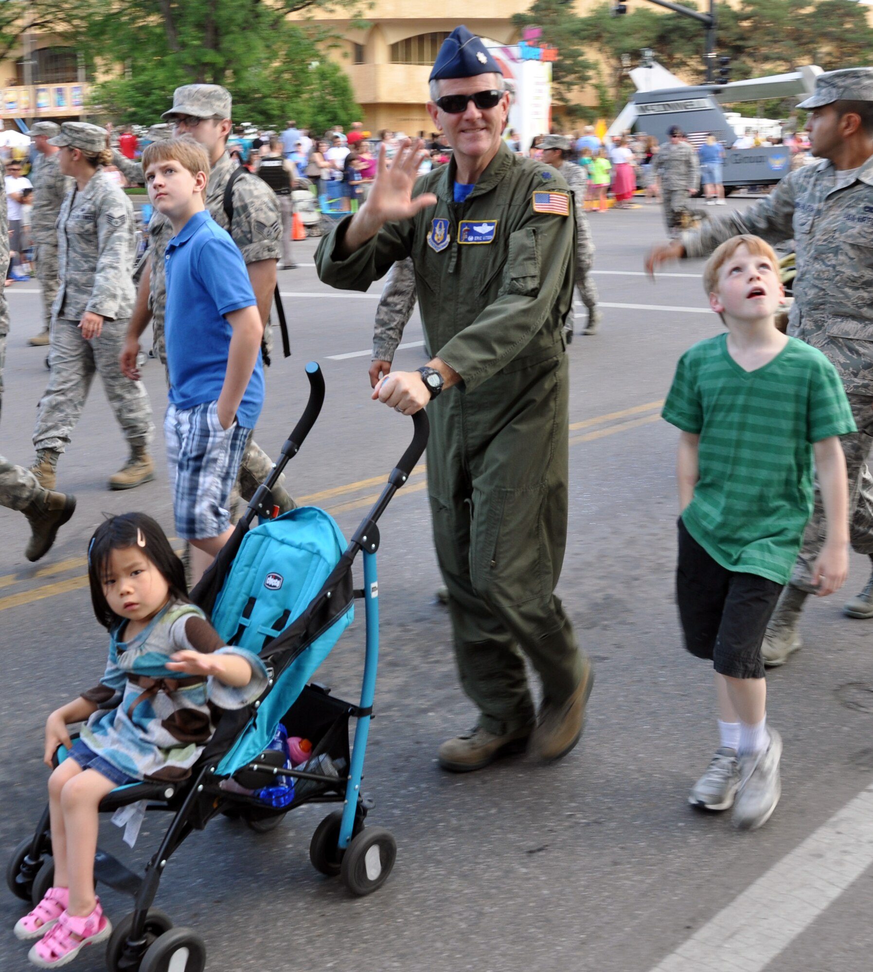 Lt. Col. Eric Vitosh, 931st Air Refueling Group, walks with his family and waves to the crowd during the  Wichita Riverfest "Sundown Parade" in downtown Wichita, Kan., May 30, 2014.  The annual parade marks the kickoff of the week-long community festival. Each year, members of the 22nd Air Refueling Wing, the Air Force Reserve 931st Air Refueling Group, and the Kansas Air National Guard184th Intelligence Wing participate in the parade. (U.S. Air Force photo by Capt. Zach Anderson)