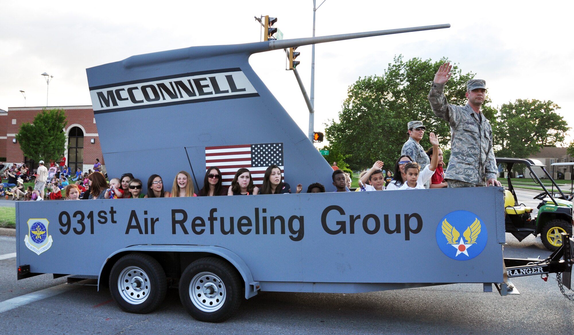 Members of team McConnell and their family members ride in the McConnell Air Force Base parade float during the  Wichita Riverfest "Sundown Parade" in downtown Wichita, Kan., May 30, 2014.  The annual parade marks the kickoff of the week-long community festival. Each year, members of the 22nd Air Refueling Wing, the Air Force Reserve 931st Air Refueling Group, and the Kansas Air National Guard184th Intelligence Wing participate in the parade. (U.S. Air Force photo by Capt. Zach Anderson)