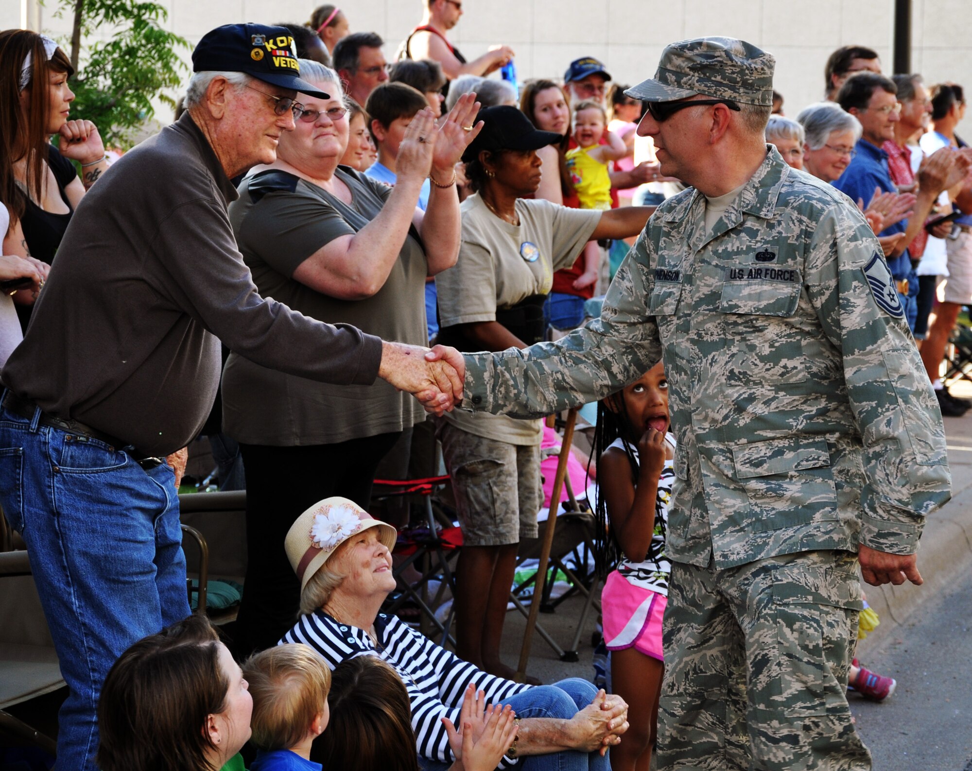Master Sgt. Johnny Stephenson, 931st Air Refueling Group, McConnell Air Force Base, Kan., shakes the hand of a Korean War Veteran and thanks him for his service during the annual Wichita Riverfest "Sundown Parade," Wichita, Kan., May 30, 2014.  Stephenson was one of more than 100 active duty, reserve, and Air National Guard Airmen from McConnell who joined together to represent the base and participate in the parade.  (U.S. Air Force photo by Capt. Zach Anderson) 
