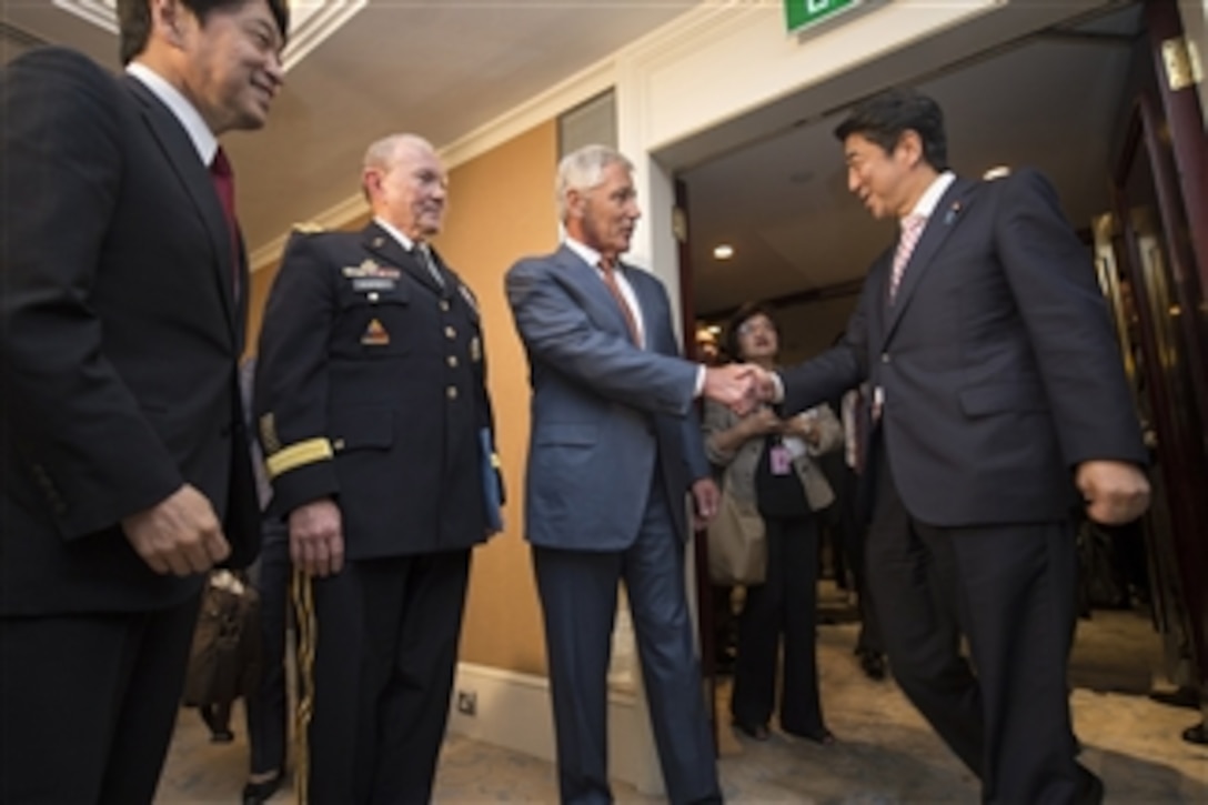 U.S. Defense Secretary Chuck Hagel, center, and U.S. Army Gen. Martin E. Dempsey, left, chairman of the Joint Chiefs of Staff, meet with Japanese Prime Minister Shinzo Abe at the Shangri-La Hotel in Singapore, May 30, 2014.