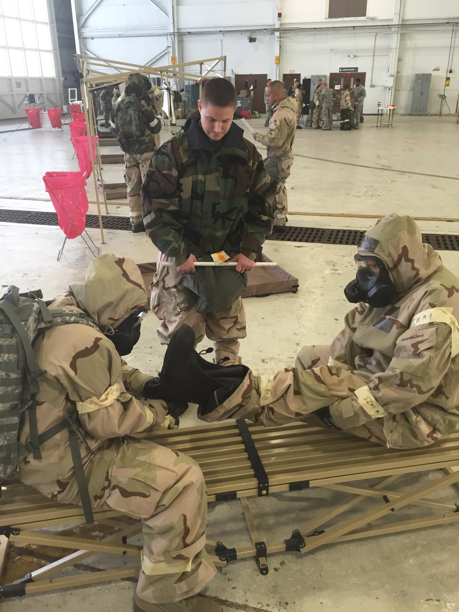 Rescue reservists with the 920th Rescue Wing, Patrick Air Force Base, Fla., give each other a hand during the boot removal station in a simulated decontamination line November 1, 2014. The 920th RQW trains and equips 1,800 Citizen Airmen to search for, locate and recover U.S. Armed Forces and coalition personnel during military operations. (U.S. Air Force photo/Senior Airman Natasha Dowridge)
