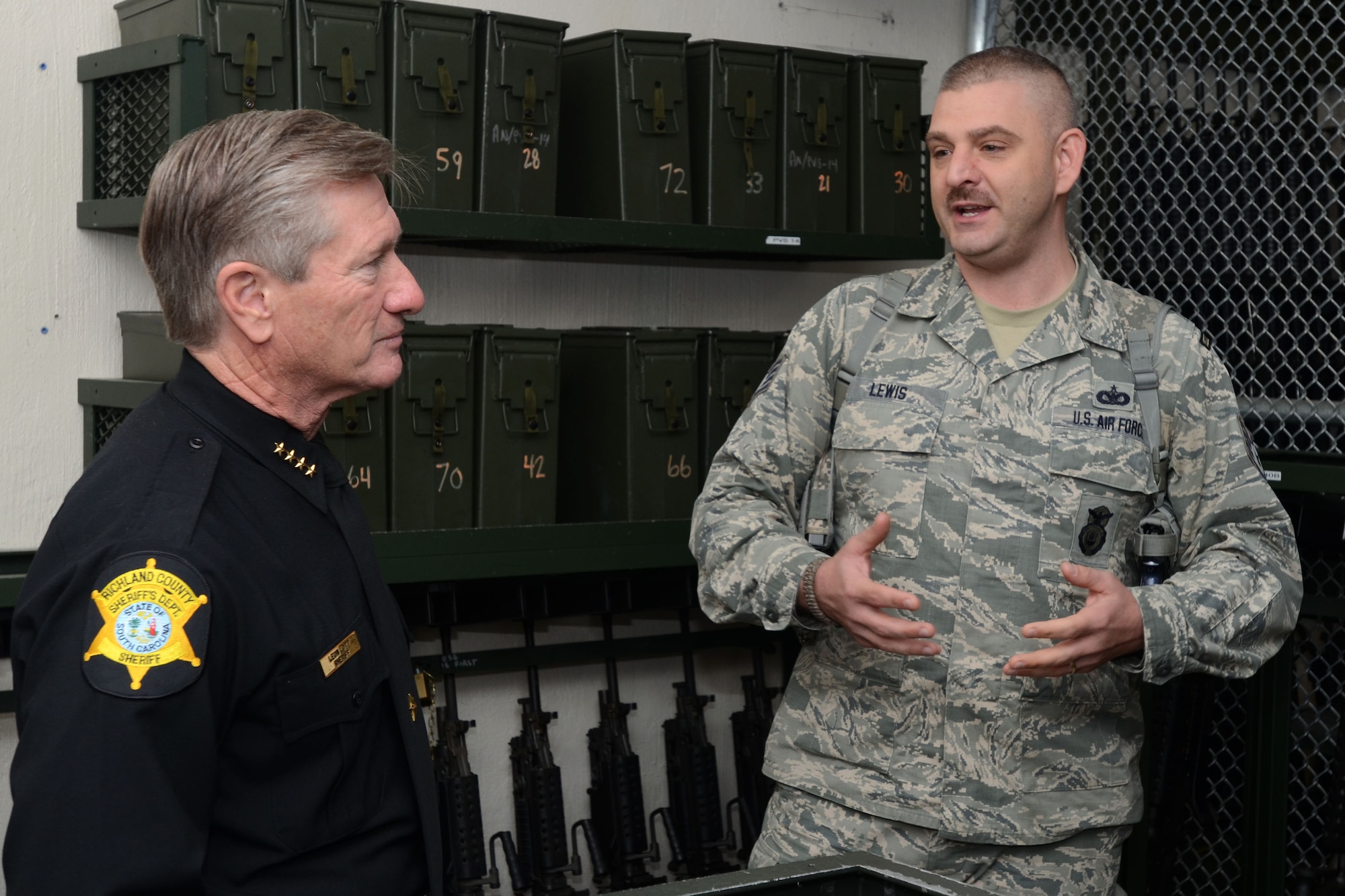 U.S. Air Force Lt. Col. Paul Laymon, the Defense Force Commander for the 169th Security Forces Squadron, and Staff Sgt. Kenvyn Lewis, combat arms trainer for the 169th SFS, give Sheriff Leon Lott, from the Richland County Sheriff's Department, a tour of the unit's armory and weapons arsenal. Sheriff Lott received the title as "Honorary Defense Force Commander" for the South Carolina Air National Guard's 169th Security Forces Squadron during a ceremony held at McEntire Joint National Guard Base, S.C., Nov. 1, 2014. This honor recognized Sheriff Lott as a community leader and supporter of the South Carolina Air National Guard to strengthen community relationships and share in team building training and experience. (U.S. Air National Guard photo by Senior Master Sgt. Edward Snyder/Released)