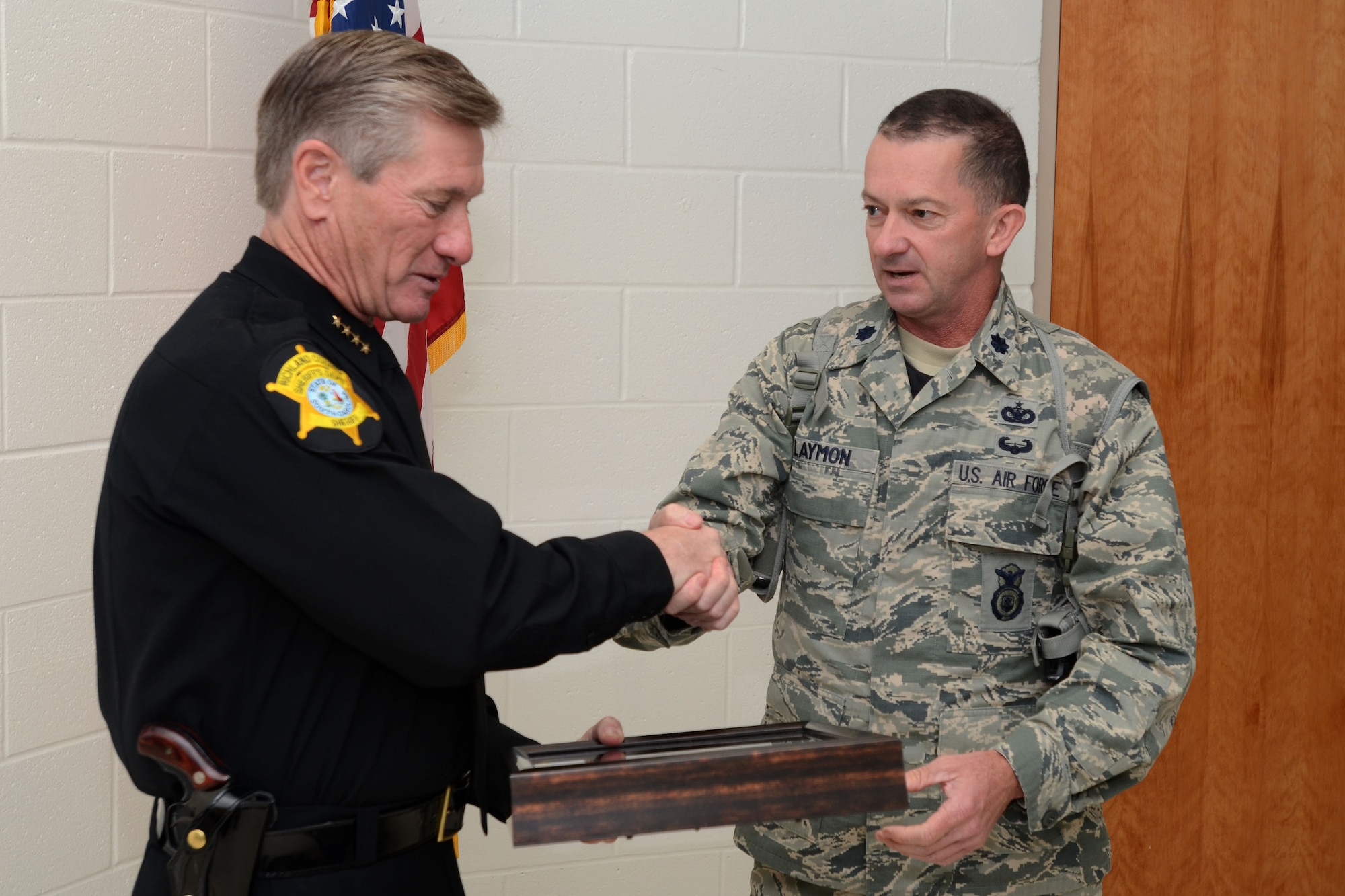 U.S. Air Force Lt. Col. Paul Laymon, Defense Force Commander for the 169th Security Forces Squadron, presents Sheriff Leon Lott, from the Richland County Sheriff's Department, with the title of "Honorary Defense Force Commander" for the South Carolina Air National Guard's 169th Security Forces Squadron during a ceremony held at McEntire Joint National Guard Base, S.C., Nov. 1, 2014. This honor recognized Sheriff Lott as a community leader and supporter of the South Carolina Air National Guard to strengthen community relationships and share in team building training and experience. (U.S. Air National Guard photo by Senior Master Sgt. Edward Snyder/Released)
