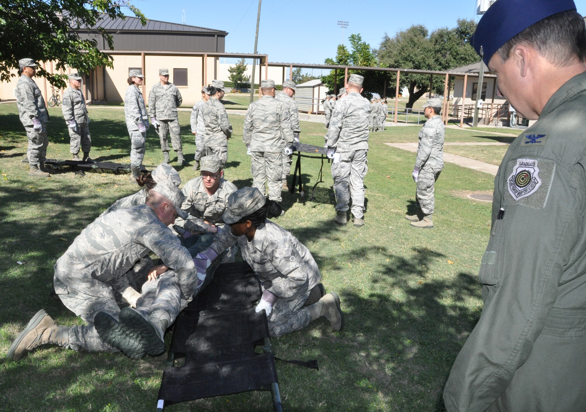 Airmen from the 301st Medical Squadron practice carrying litters, while Col. John Breazeale, 301st Fighter Wing commander, looks on during a mass casualty training Saturday, Nov. 1.  Members also practiced sending and calling in casualty reports via radio. Safety procedures for medical personnel were also reviewed. The training was held at Naval Air Station Fort Worth Joint Reserve Base, Texas. (U.S. Air Force photo by Staff Sgt. Melissa Harvey)