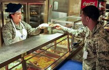 Melissa Tims, 919th Maintenance Group, passes over a lunch plate during the annual holiday meal at Duke Field Fla., Nov. 1.  919th Special Operations Wing leadership served food for the Airmen during the meal.  (U.S. Air Force photo/Dan Neely)