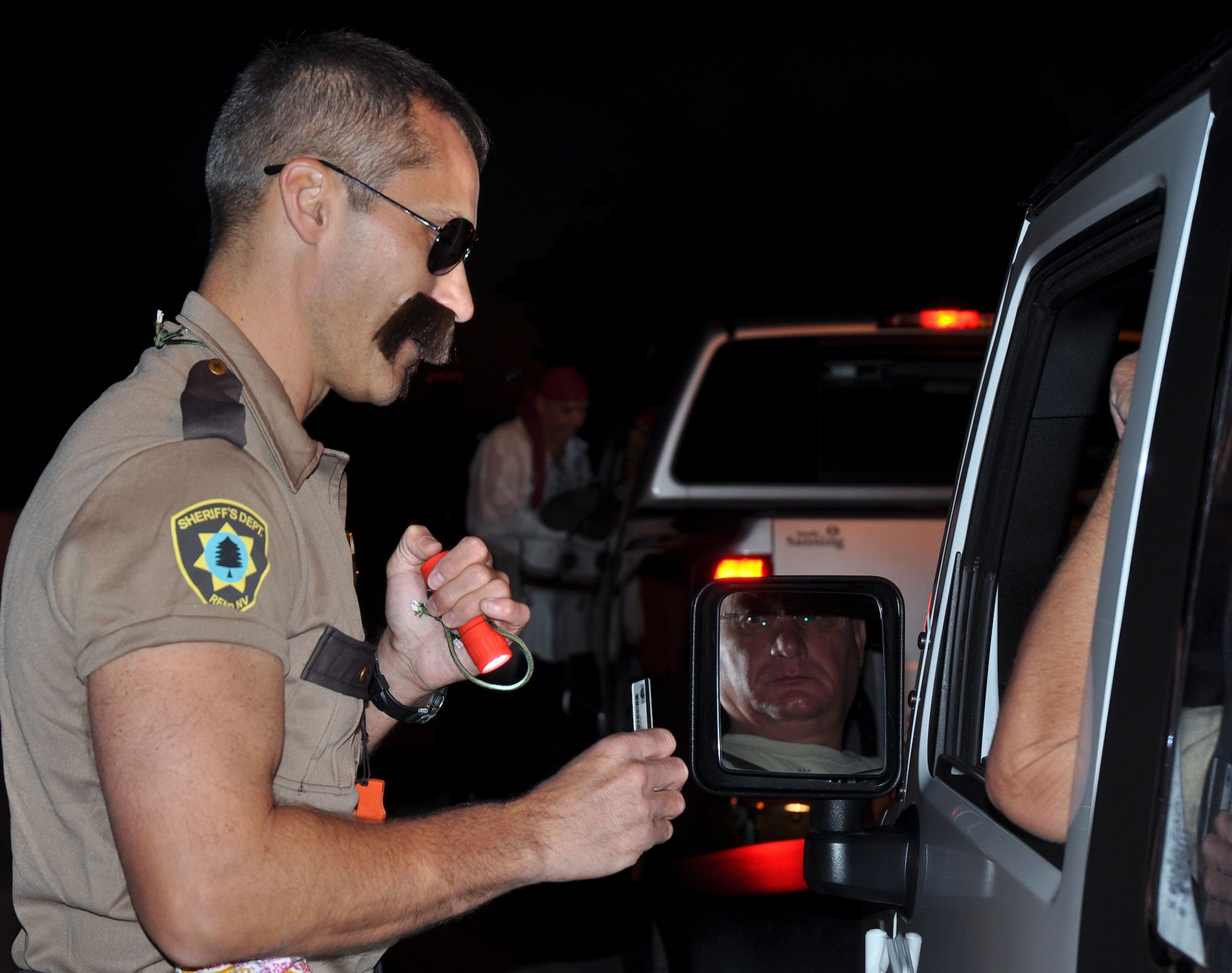 A member of the “Reno 911” Sheriff’s Department aka Col. Robert Bruckner, 919th Special Operations Wing vice commander, and Chief Master Sgt. Tom Mason, the 919th SOW command chief, dressed as a pirate check IDs and gives out candy for Halloween the morning of the November UTA.  (U.S. Air Force photo/Dan Neely)