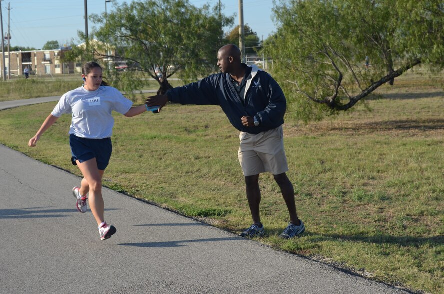 Master Sgt, Leroy Beck, a 433rd Aircraft Maintenance Squadron member and a Physical Training Leader, encourages a wing member during the run portion on the physical fitness test administered on Nov. 2, 2014 on Joint Base San Antonio-Lackland, Texas. (U.S. Air Force Photo by Capt. Philip Cortez)