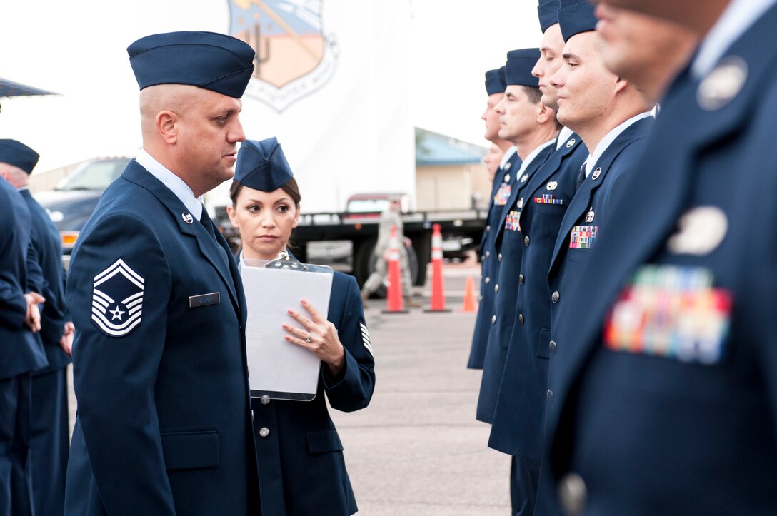 Attention to detail. With Tech. Sgt. Veronica Villegas taking notes, Senior Master Sgt. Daniel Ramirez inspects 162nd Logistics Readiness Squadron Airmen for hygiene and uniform appearance while ensuring their medals and uniforms were in line with military personnel flight records. Ramirez oversaw this open ranks inspection on Nov. 2 at the Tucson International Airport.  (U.S. Air National Guard photo by Tech. Sgt. Hollie A. Hansen/Released)
