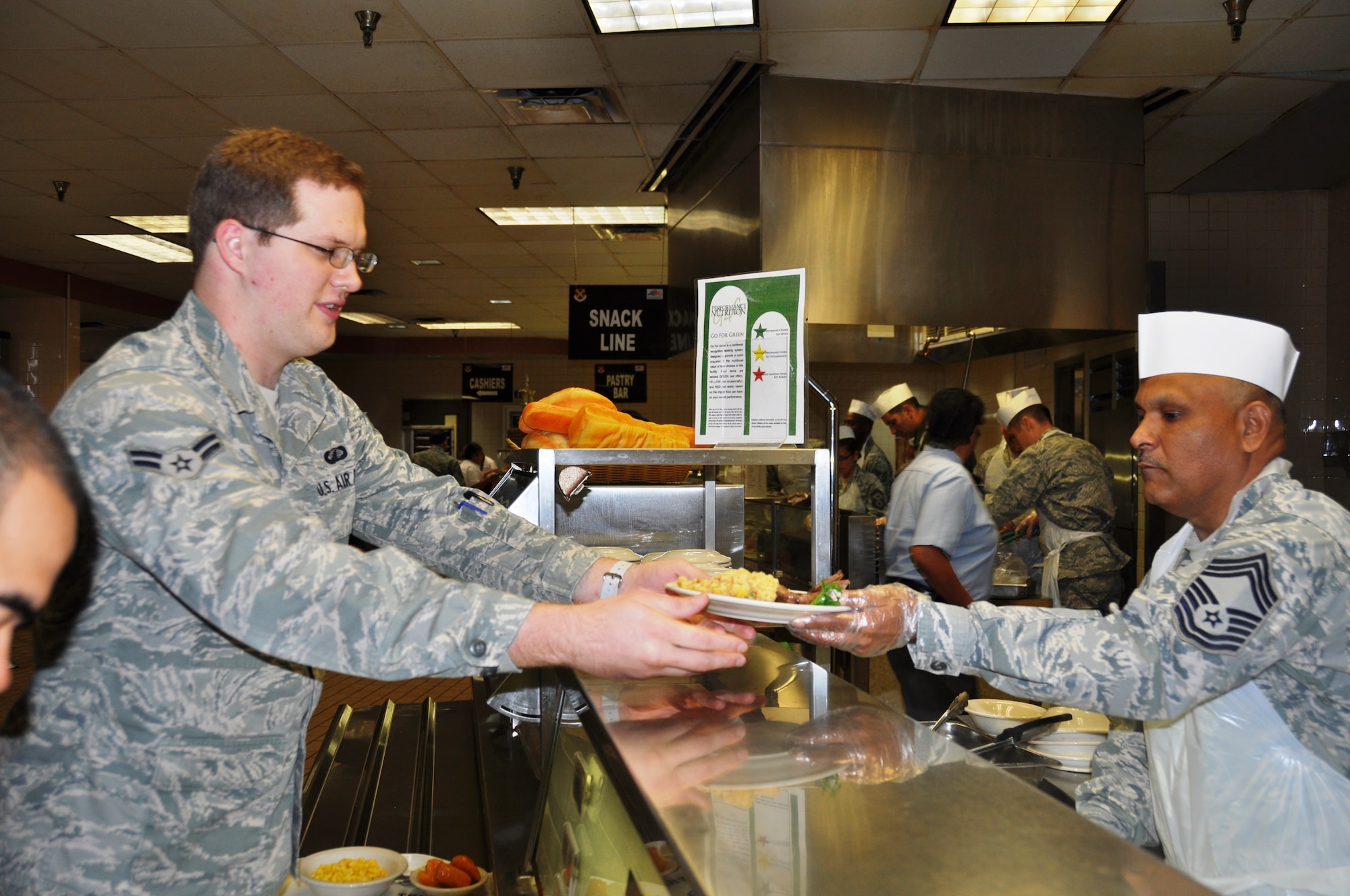 Airman 1st Class Matthew Pfenninger, a cargo ground loader specialist with the 74th Aerial Port Squadron, Joint Base San Antonio-Lackland, Texas gets a holiday themed meal from Chief Master Sgt. Richard Garcia, 26th Aerial Port Squadron, operations chief, at the Live Oak Dining Facility Nov. 1, 2014. (U.S. Air Force photo by Tech Sgt. Carlos J. Trevino)

