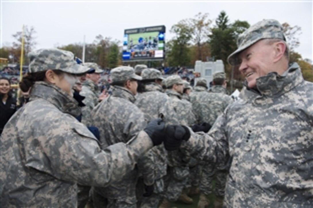 Army Gen. Martin E. Dempsey, chairman of the Joint Chiefs of Staff, right, bumps fists with a U.S. Military Academy cadet on the sideline at Michie Stadium in West Point, N.Y., during the Air Force-Army football game, Nov. 1, 2014. Air Force beat Army, 23-6. 