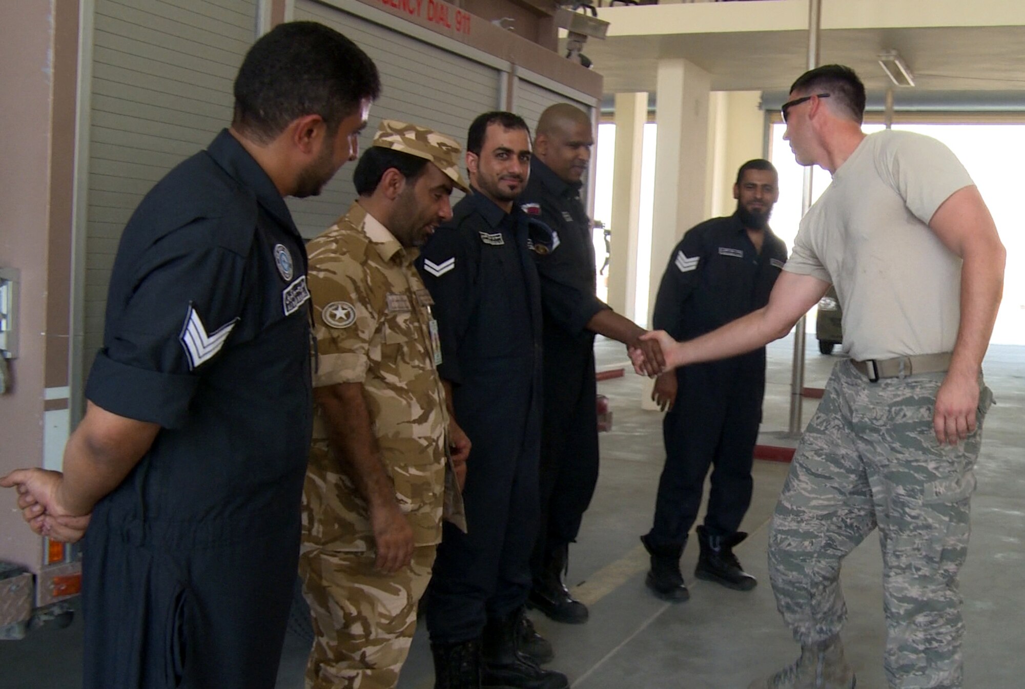 A U.S. Air Force firefighter from the 379th Expeditionary Civil Engineer Squadron shakes hands with Qatari Emiri Air Force firefighters during bilateral training Oct. 30, 2014, at Al Udeid Air Base, Qatar. This training enhances their working relationship and enables them to do what they are trained to do which is saving lives and preserving property.