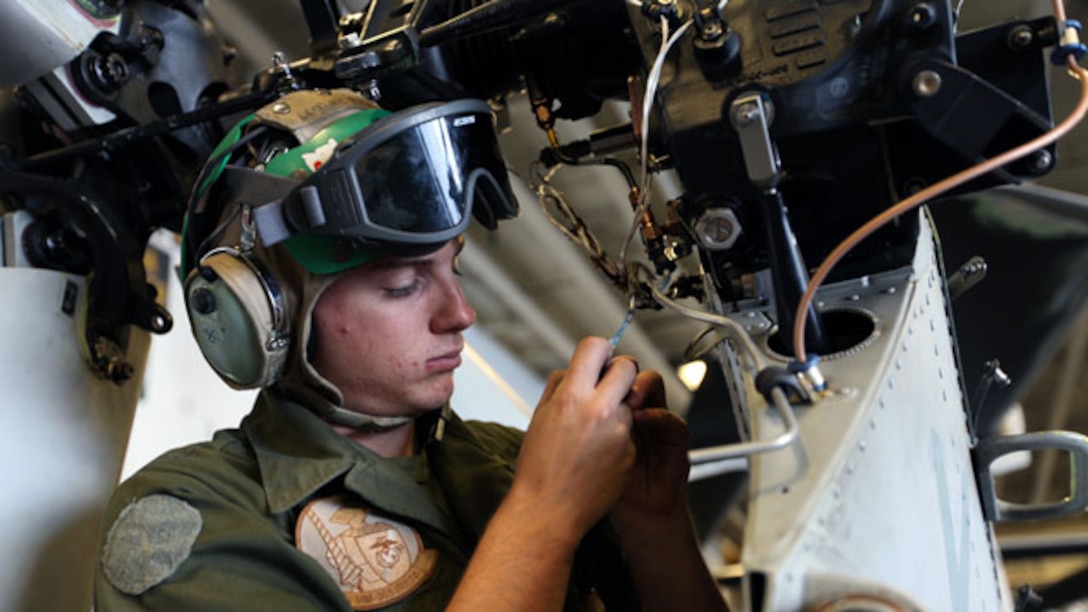 Sergeant Tyler W. Envall, an H-1 avionics technician with the 24th Marine Expeditionary Unit’s Aviation Combat Element, Marine Medium Tiltrotor Squadron 365, conducts 90-degree gear box wiring of a UH-1Y Huey aboard the USS Iwo Jima, Oct. 27, 2014. Marines conduct flight maintenance around the clock to maintain mission readiness for all MEU aircraft. (U.S. Marine Corps photo by Sgt. Devin Nichols)