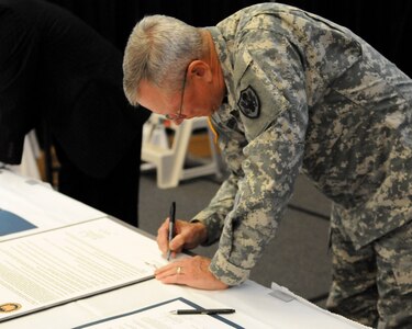 Army Gen. Frank Grass, chief of the National Guard Bureau, signs a Memorandum of Understanding, which is designed to assist National Guard Families, Camp Dawson, W. Va., Oct. 29, 2014. Grass, along with Sonny Ramaswamy, director, National Institute of Food and Agriculture, signed the Memorandum of Understanding that will better enhance the health and well-being of military families. 
