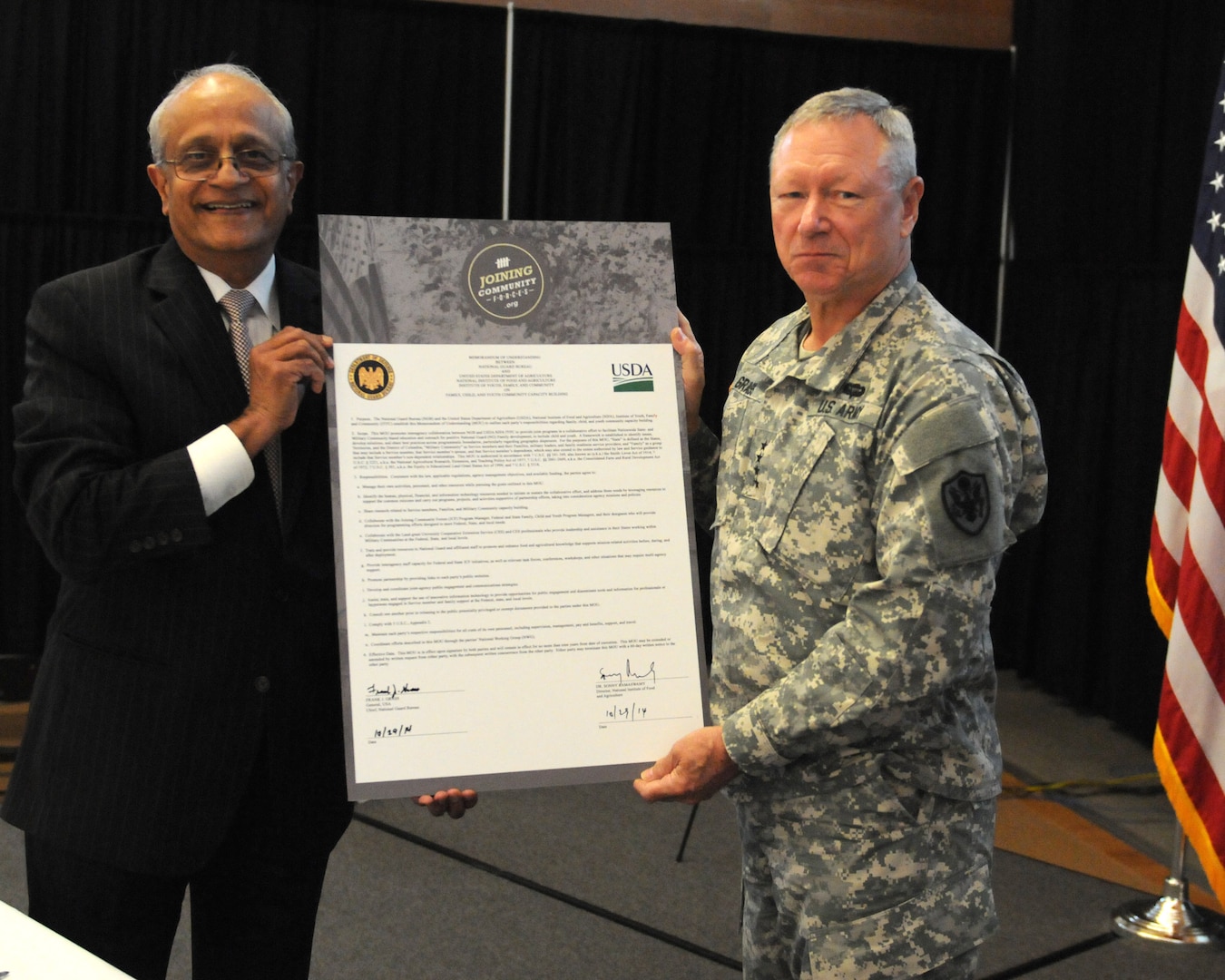Army Gen. Frank Grass, chief of the National Guard Bureau and Sonny Ramaswamy, director, National Institute of Food and Agriculture, stand together after signing a Memorandum of Understanding, which is designed to assist National Guard families, Camp Dawson, W. Va., Oct. 29, 2014. The memorandum of understanding was signed to connect the two organizations to better enhance the health and well-being of military families.