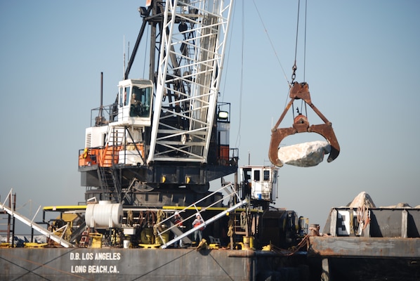 A Connolly Pacific crane operator moves a 9-ton rock into position along the Port of Long Beach Middle Breakwater. Repair work on the breakwater is being accomplished under a Corps of Engineers contract to repair damage suffered in late August during heavy seas from Hurricane Marie.