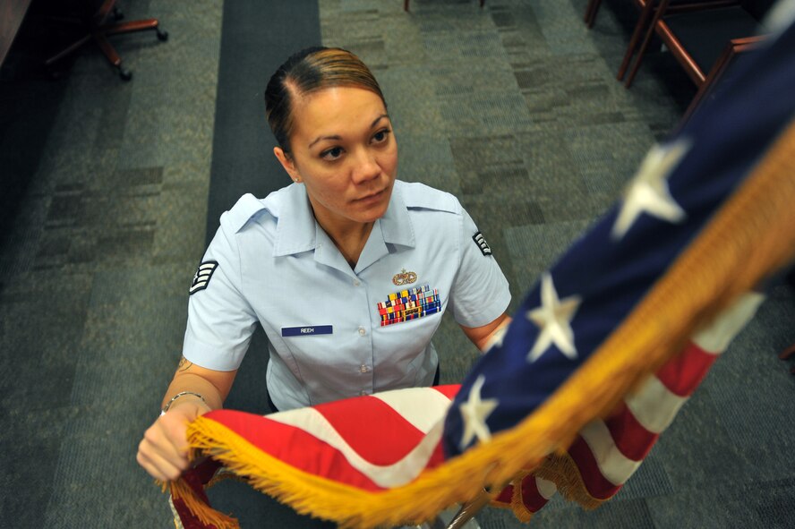 Staff Sgt. Kayla Reeh, 92nd Air Refueling Wing Protocol specialist, adjusts the American flag prior to a ceremony, Oct. 29, 2014, at Fairchild Air Force Base, Wash. Andrew Brinkman, 92nd ARW Protocol officer, selected Reeh as a member of Team Fairchild’s elite, Fairchild’s Finest. (U.S. Air Force photo/Staff Sgt. Veronica Montes)