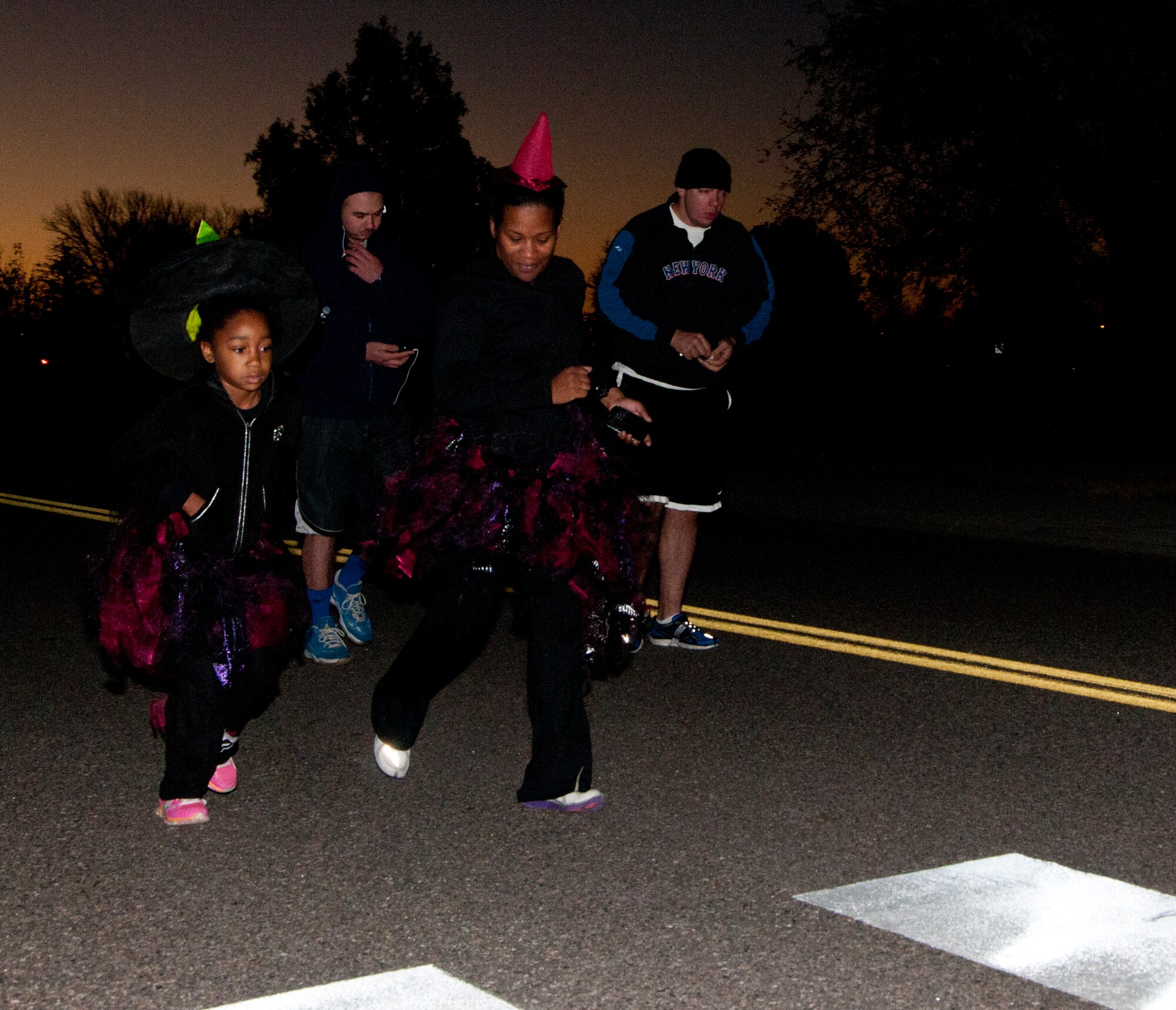 A group of runners take off at the beginning of the 90th Force Support Squadron Halloween 5K Oct. 30, 2014. Runners dressed up in Halloween costumes, and some without, braved the frigid temperatures that morning to take part in the seasonal competition. (U.S. Air Force photo by Senior Airman Jason Wiese)
