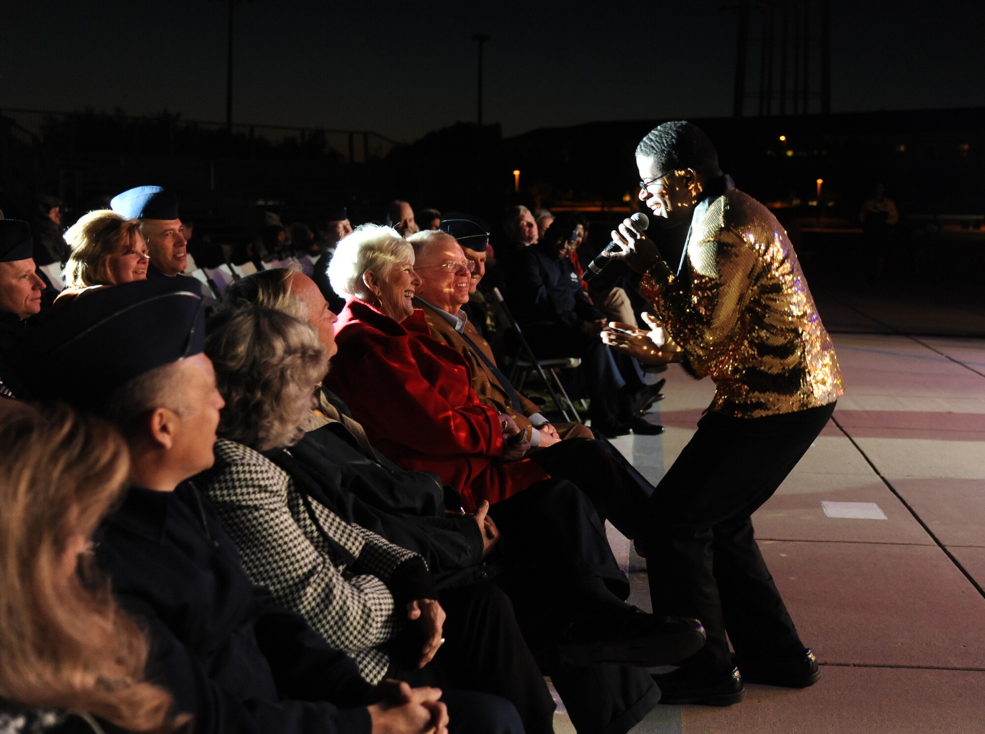 Staff Sgt. Marc Hightower sings to Earline Sawyer during a performance by Tops in Blue during their 2014 World Tour Nov. 1, 2014, behind the Levitow Training Support Facility, Keesler Air Force Base, Miss.  Hundreds of Keesler Airmen, families and retirees watched and listened as the Tops in Blue members performed their diverse show celebrating 60 years of tradition. Hightower is an aircraft electrical and environmental system craftsman from the 18th Aircraft Maintenance Squadron, Kadena Air Base, Japan.  Earline is the spouse of Lenny Sawyer, 81st Training Wing honorary commander. (U.S. Air Force photo by Kemberly Groue)