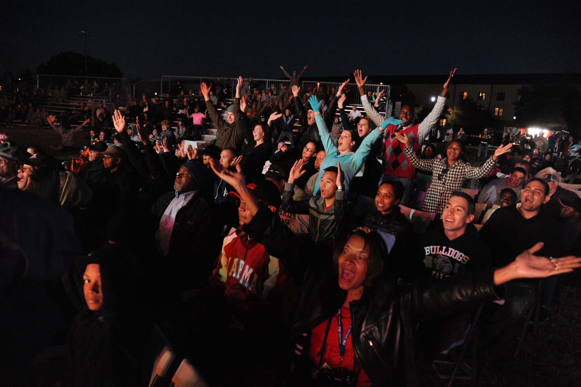 Members of the audience participate during the Tops in Blue performance of the song “Y.M.C.A.” during their 2014 World Tour Nov. 1, 2014, behind the Levitow Training Support Facility, Keesler Air Force Base, Miss.  Hundreds of Keesler Airmen, families and retirees watched and listened as the Tops in Blue members performed their diverse show celebrating 60 years of tradition. (U.S. Air Force photo by Kemberly Groue)