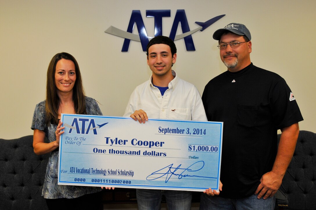 Tyler Cooper (second from left) accepts a $1,000 ATA Vocational Technology Scholarship from Susan Davis (left), with the Aerospace Testing Alliance (ATA) Human Resources Branch. Cooper is joined by his father and ATA employee James Melton. (Photo by Rick Goodfriend)