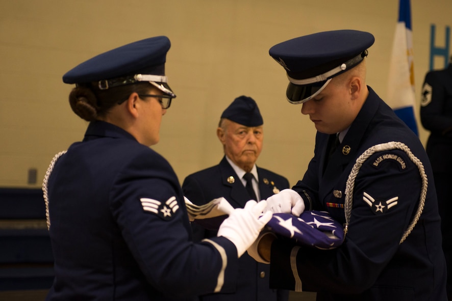 U.S. Air Force Airman 1st Class Michael Pitts, right, and Senior Airman Michelle Sharp, Moody Honor Guard ceremonial guardsmen, fold the U.S. flag for retired U.S. Air Force Chief Master Sgt. Earl Hendrix, former 347th Tactical Fighter Wing senior enlisted advisor, during the Retiree Appreciation Day opening ceremony Nov. 1, 2014, at Moody Air Force Base, Ga. The guardsmen folded the flag to present the “Hero Award” to Hendrix for his many years of volunteer work. (U.S. Air Force photo by Airman 1st Class Dillian Bamman/Released)