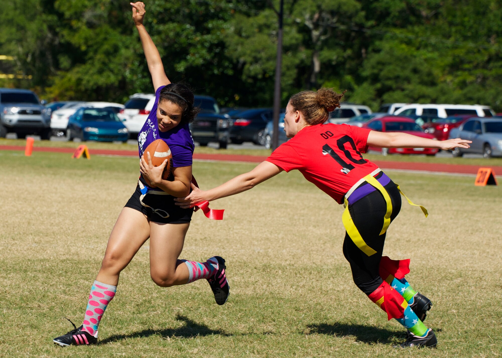 Senior Airman Myishia Davis, of the 96th Logistics Readiness Squadron, darts to the right to avoid her 96th Force Support Squadron defender during their powderpuff football game Oct. 31 at Eglin Air Force Base, Fla. LRS, the reigning champions, took home the win in a 13-0 victory by scoring a touchdown in each half and stopping FSS short in the red zone twice. Davis scored one of the two touchdowns for LRS. The annual powderpuff game coincided with the 96th Test Wing’s Wingman Day which focused on strengthening relationships and showing respect and resiliency in the workplace. (U.S. Air Force photo/Sara Vidoni)