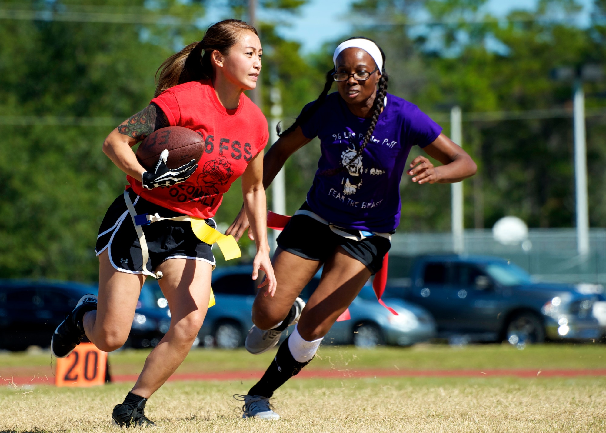 Airman 1st Class Linda Cha, of the 96th Force Support Squadron, attempts to outrun her 96th Logistic Readiness Squadron defender during their powderpuff football game Oct. 31 at Eglin Air Force Base, Fla. LRS, the reigning champions, took home the win in a 13-0 victory by scoring a touchdown in each half and stopping FSS short in the red zone twice. The annual powderpuff game coincided with the 96th Test Wing’s Wingman Day which focused on strengthening relationships and showing respect and resiliency in the workplace. (U.S. Air Force photo/Sara Vidoni)