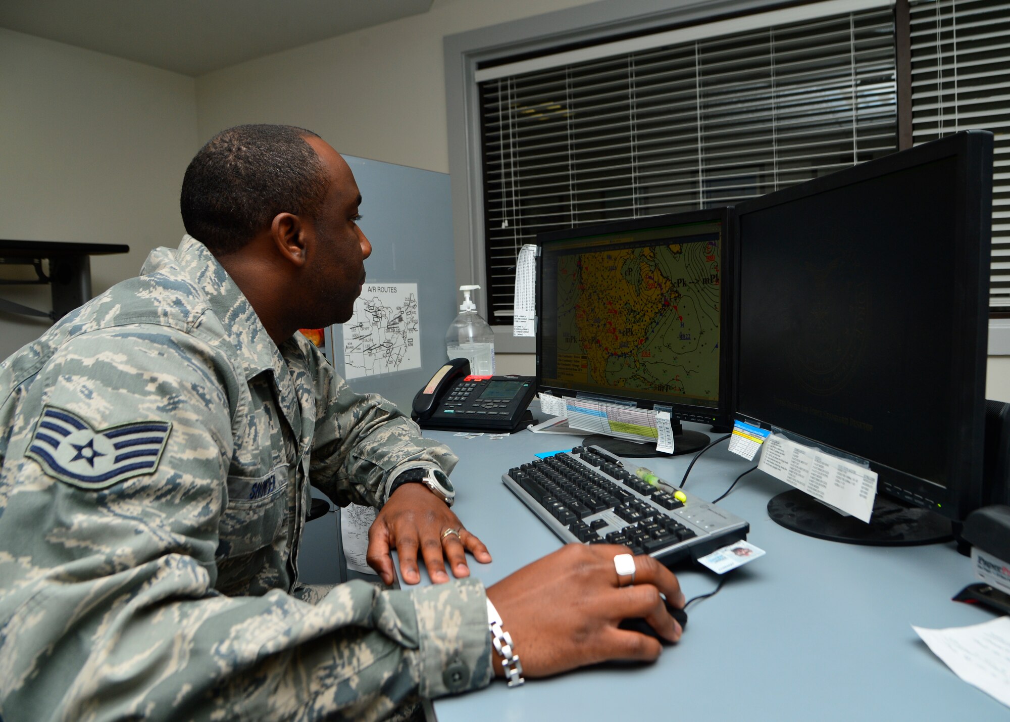 Staff Sgt. Justin Snowden, 436th Operations Support Squadron weather technician, observes a surface analyses chart Oct. 30, 2014, at Dover Air Force Base, Del. The surface analyses chart provides the first step delivering a synoptic overview of the weather patterns. (U.S. Air Force photo/Airman 1st Class William Johnson)